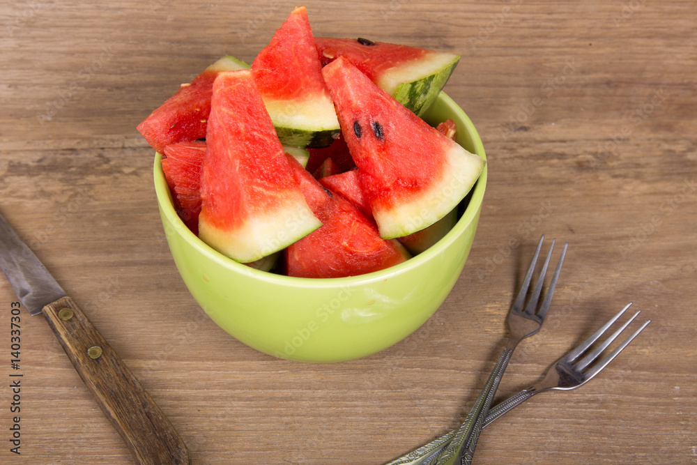 slices of watermelon on brown wooden background slices of watermelon on brown wooden background
