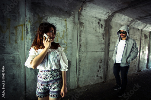Social Issues,Beautiful woman on the phone while walking in the tunnel and being stalked by stranger