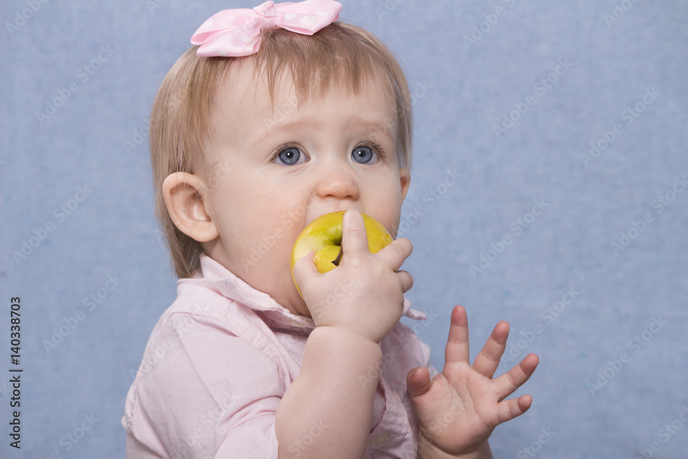 Cute little girl eating big green apple. Retro shot Cute little girl eating big green apple. Retro shot