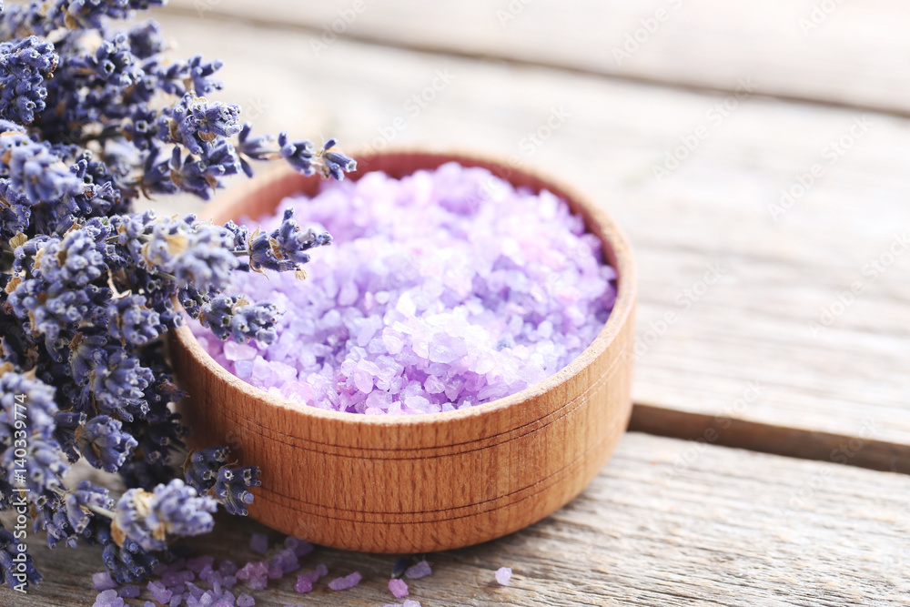 Bunch of lavender flowers with sea salt in bowl on grey wooden table