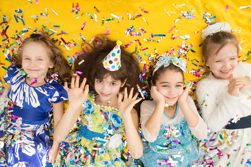 Happy children celebrating party with blowing confetti top view. The girls in birthday party. Positive emotions. .