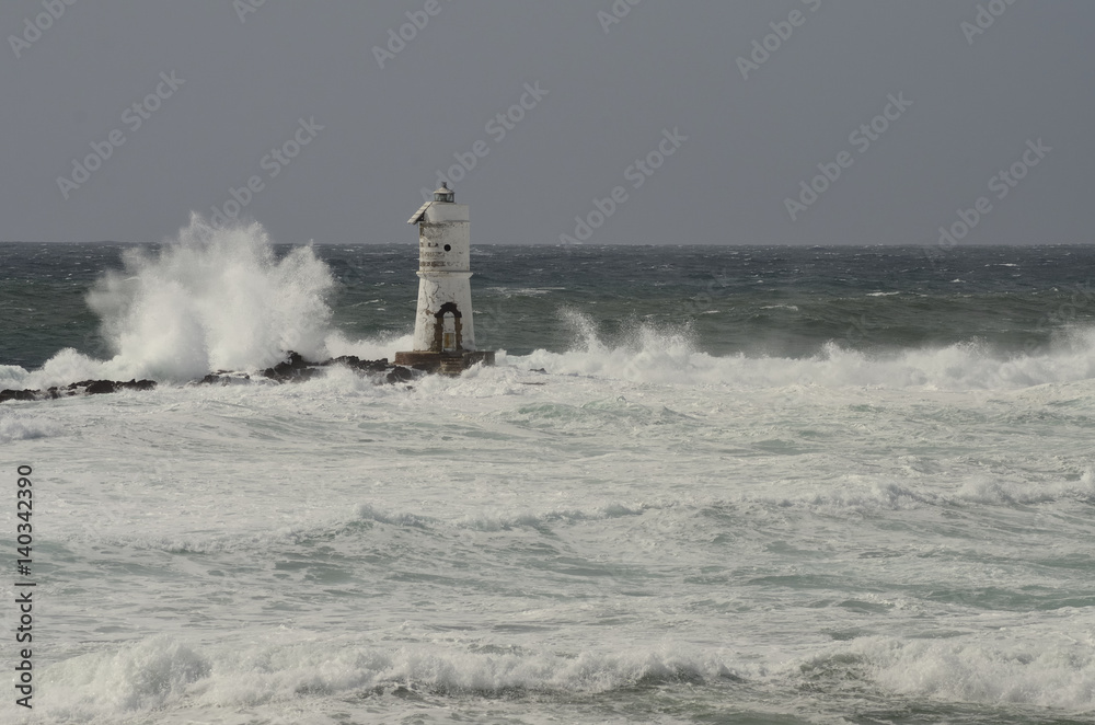 Italy, 'Mangiabarche', Storm. Waves smash against lighthouse or beacon.