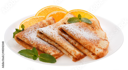 Serving pancakes with orange slices on the plate.