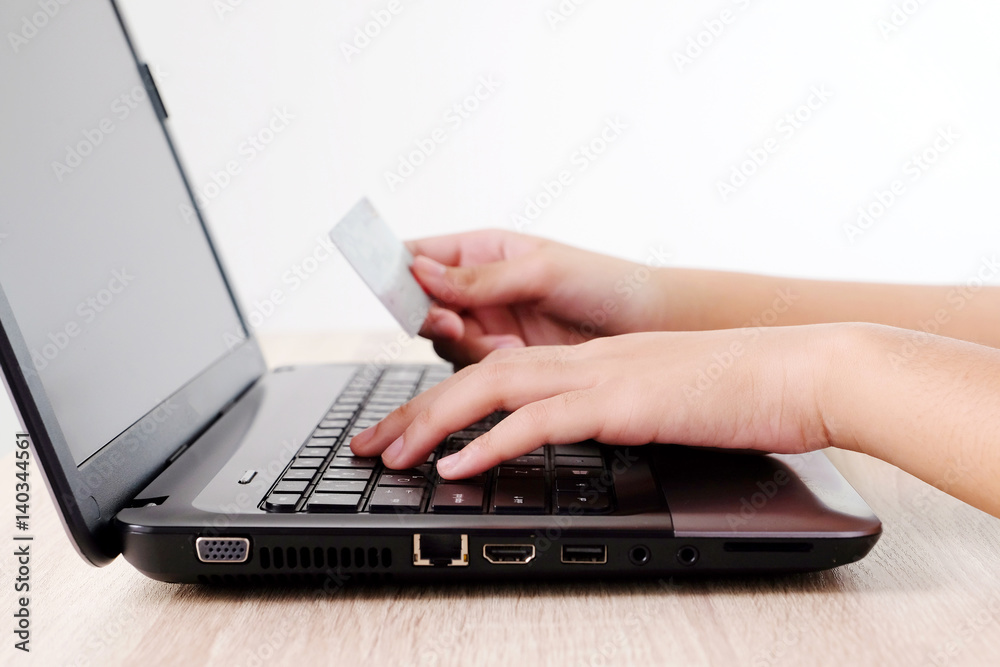Woman hands holding credit card and typing labtop on table background, selective focus, shopping online concept, business and technology Woman hands holding credit card and typing labtop on table background, selective focus, shopping online concept, business and technology