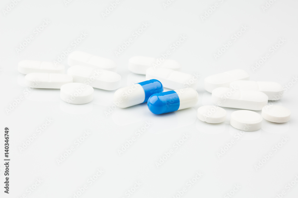 Pharmacy theme.Blue capsules and white antibiotic pills.