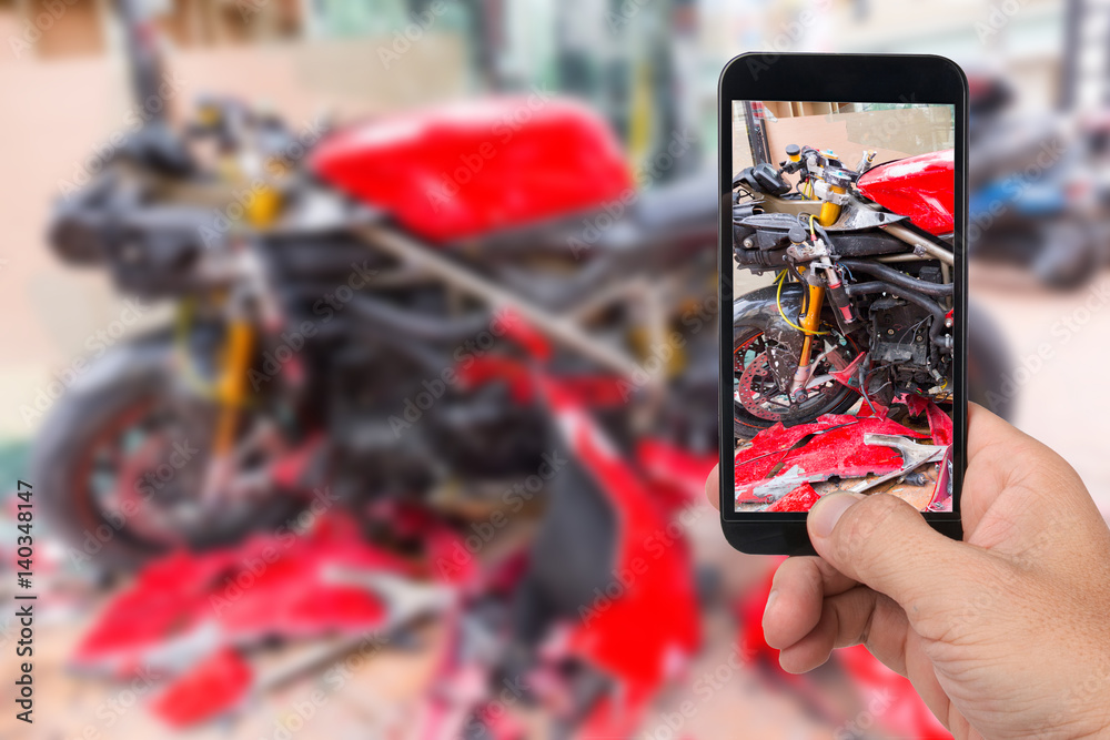 Obraz premium Close up hand holding smartphone and take photo of motorbike accident