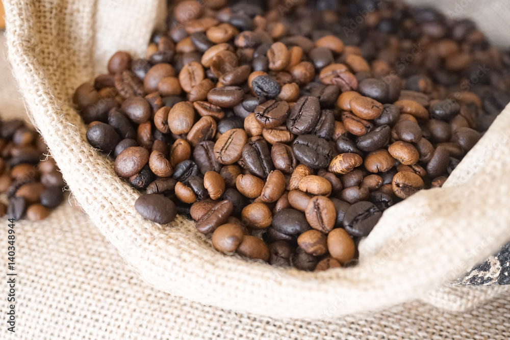 Fototapeta premium Coffee beans in a coffee sack bag (burlap bag) with soft window light