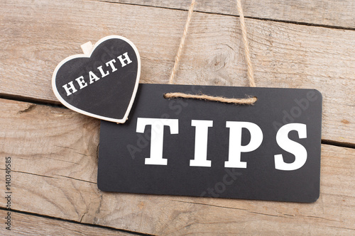 blackboard with text "Health tips" on wooden background