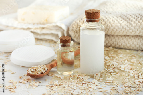
Homemade skincare cosmetic. Rice water and oat flakes facial cleanser. Bottle of cereal milk, grains, towels and cotton pads. 