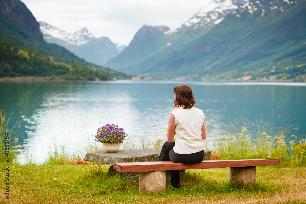 Woman tourist relaxing on fjord sea shore, Norway