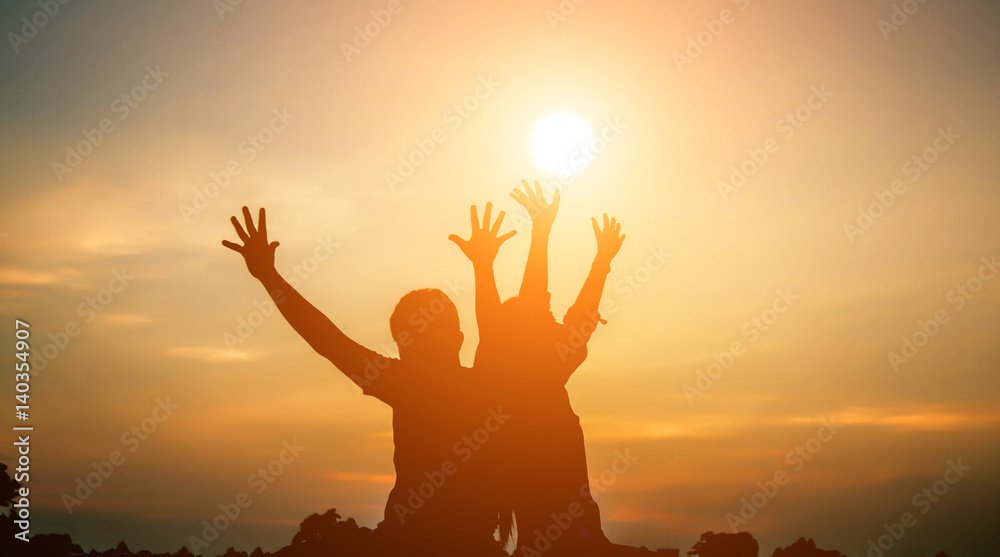 Man and woman hold hands in the sunset.
