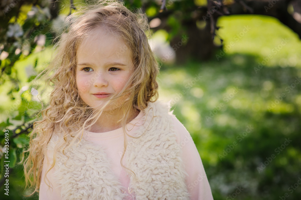 spring portrait of beautiful dreamy curly 5 years old child girl walking in blooming garden spring portrait of beautiful dreamy curly 5 years old child girl walking in blooming garden