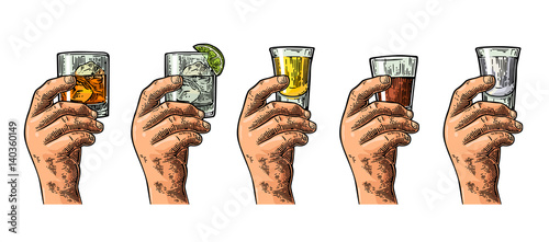 Male hand holding glasses with tequila, vodka, rum, gin, whiskey.