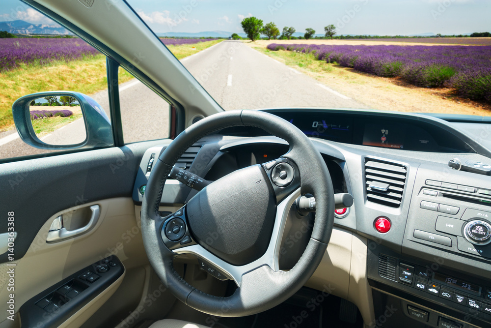 car windscreen with summer road and lavemder filed, view inside out