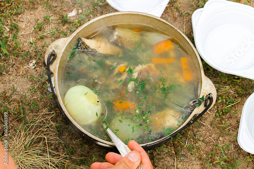 Testing the soup. Chowder cooked in nature. photo