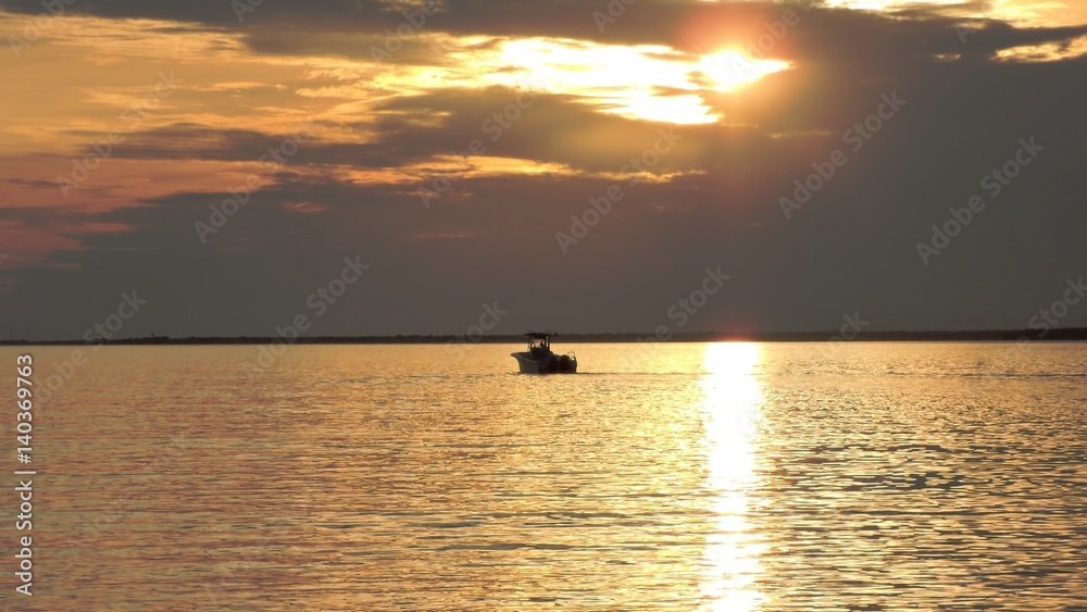 boat caught in golden sunset on the bay