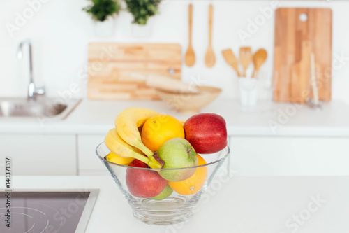 Fresh fruit in a glass bowl in a kitchen photo