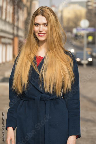 Portrait of a young beautiful woman in blue coat © Andrey_Arkusha