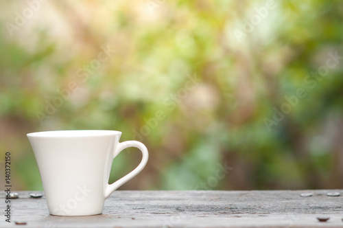 Coffee mug with blurry nature background.