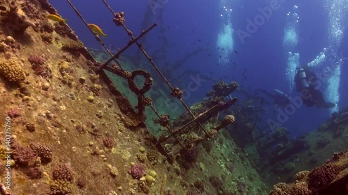 Wreck ship underwater on coral reef Abu Nuhas on blue background in Red sea. Swimming in world of colorful beautiful wildlife of fish and algae. Inhabitants in search of food. Abyssal diving. photo