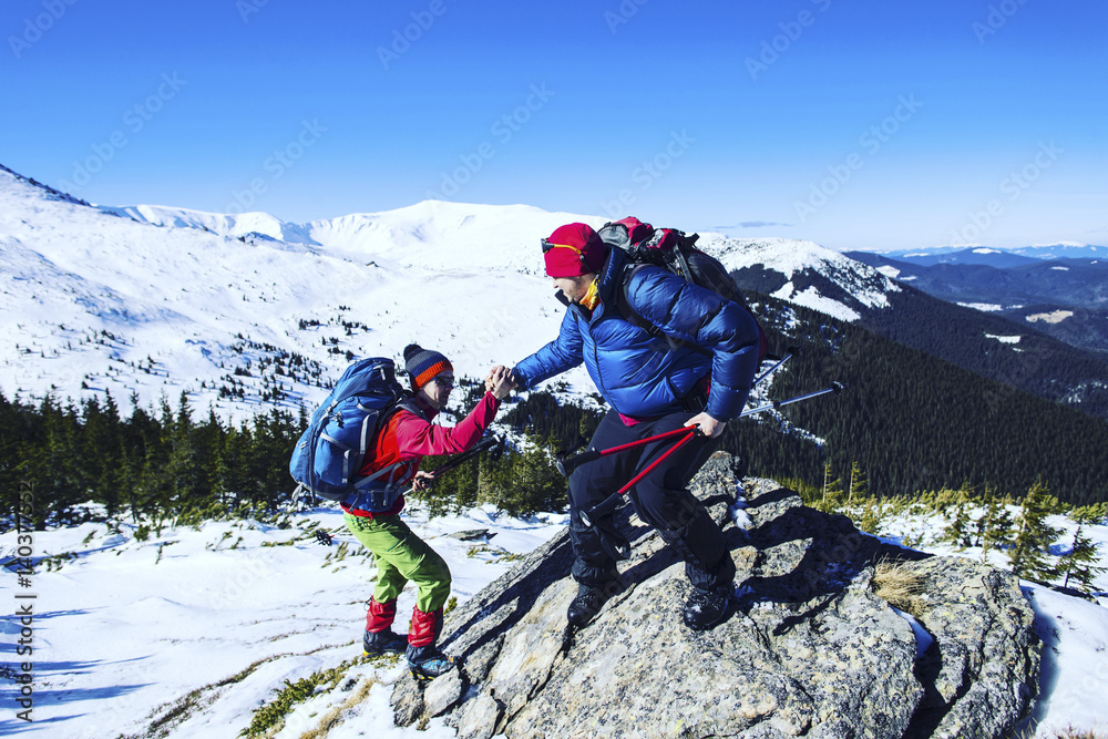 Man giving helping hand to friend to climb mountain rock cliff. Man giving helping hand to friend to climb mountain rock cliff.