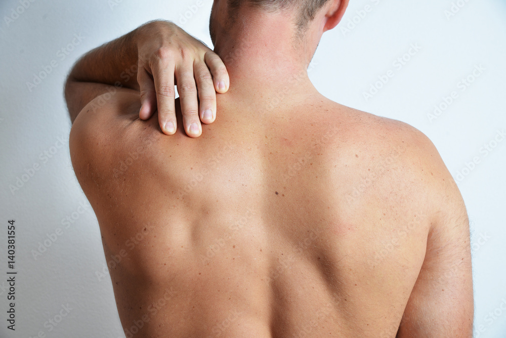 Concept of a pain in back shoulder of adult man, isolated on the white background