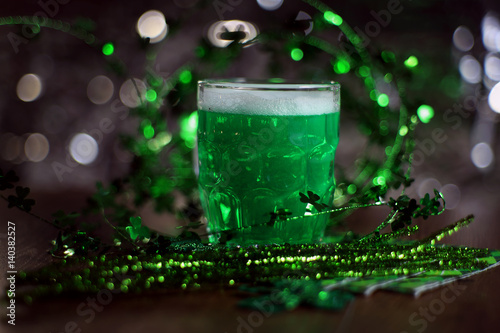 St patricks day. St. Patricks Day decoations with green beer. Irish green beer, traditional alcohol for St. Patrick's day holiday celebration. Glass of green beer with clover leaves on wooden table.