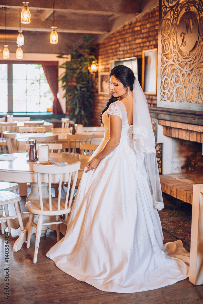 Beautiful bride with flowers in a luxurious restaurant. Vintage style.