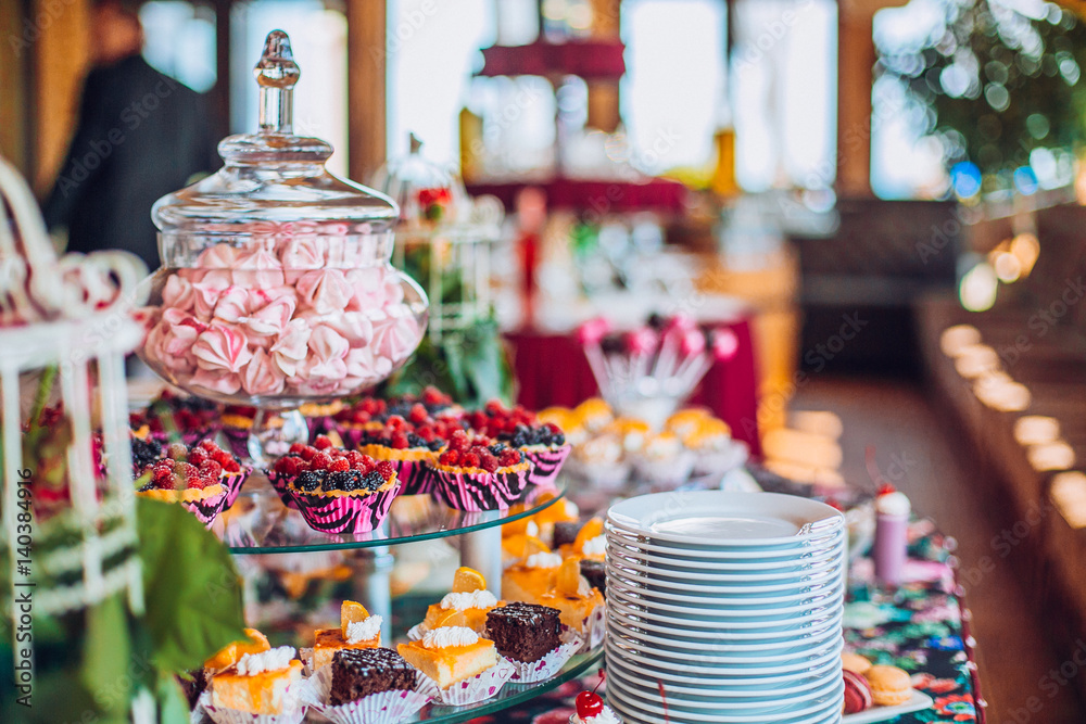 Delicious sweets on candy buffet. Lot of colorful desserts on table.