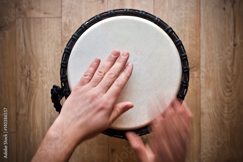 hands playing on djembe drum photo