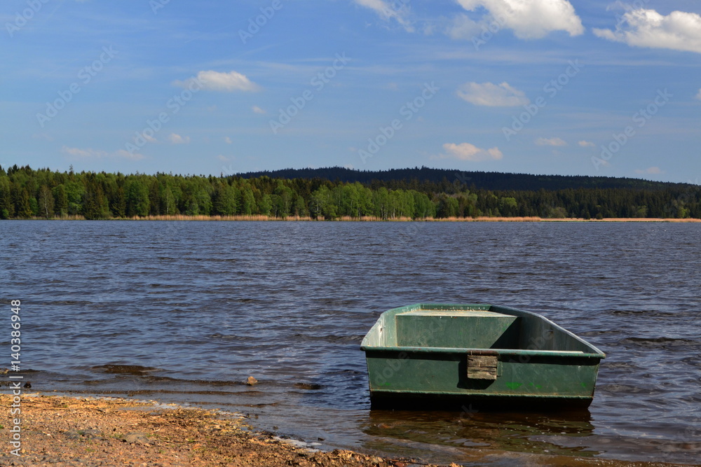 rowboat near the shore of a pond on a summer day
