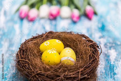 Happy Easter background, Easter eggs in nest and tulips photo