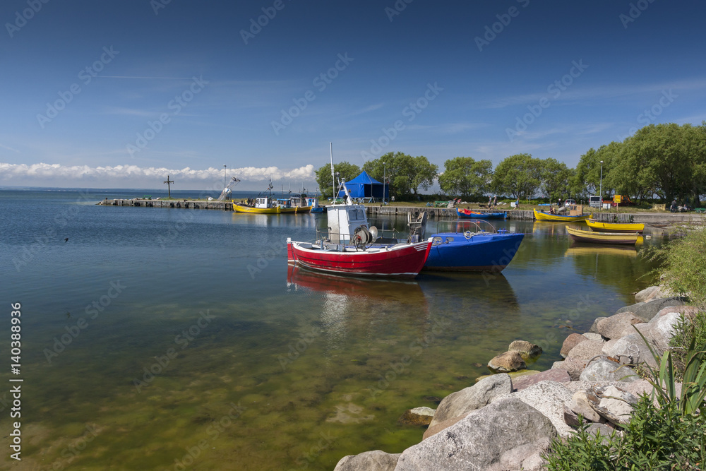 Summer view of a small harbor with wooden boats