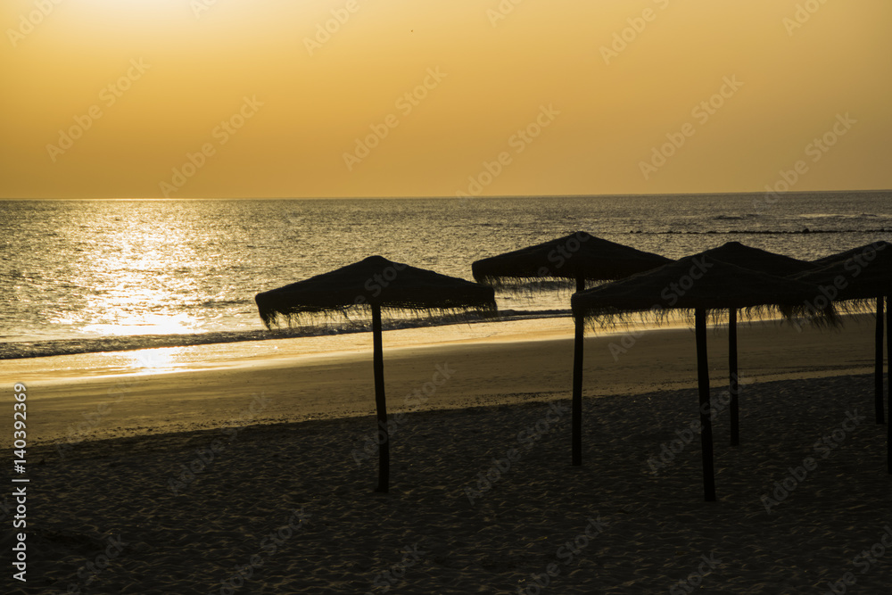 Sunset over a beach with umbrellas