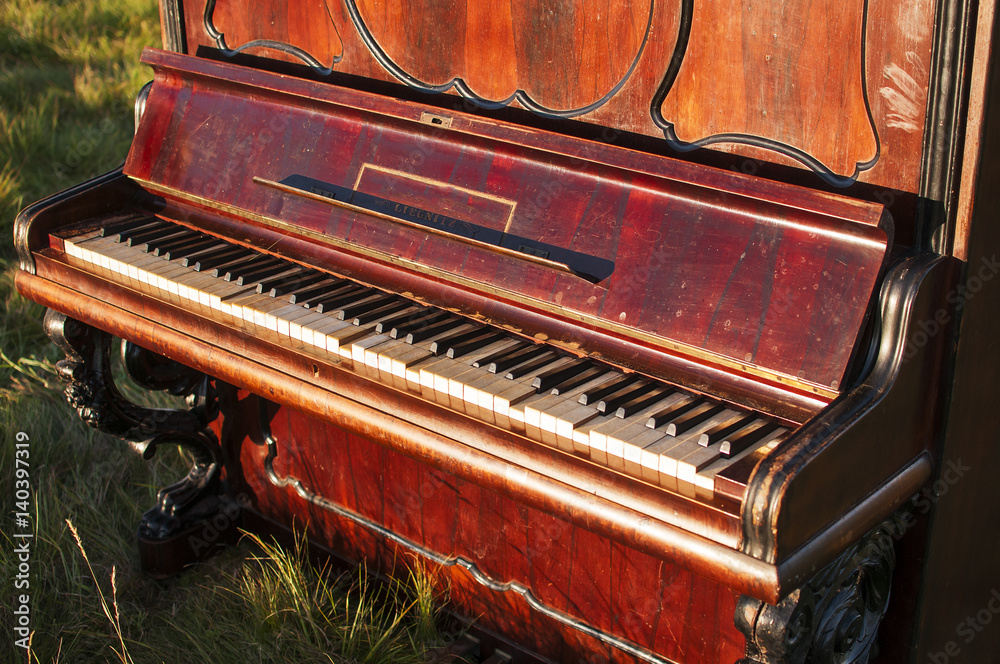 Old brown classical piano in the middle of the field outside and staying on  the green grass Stock Photo | Adobe Stock