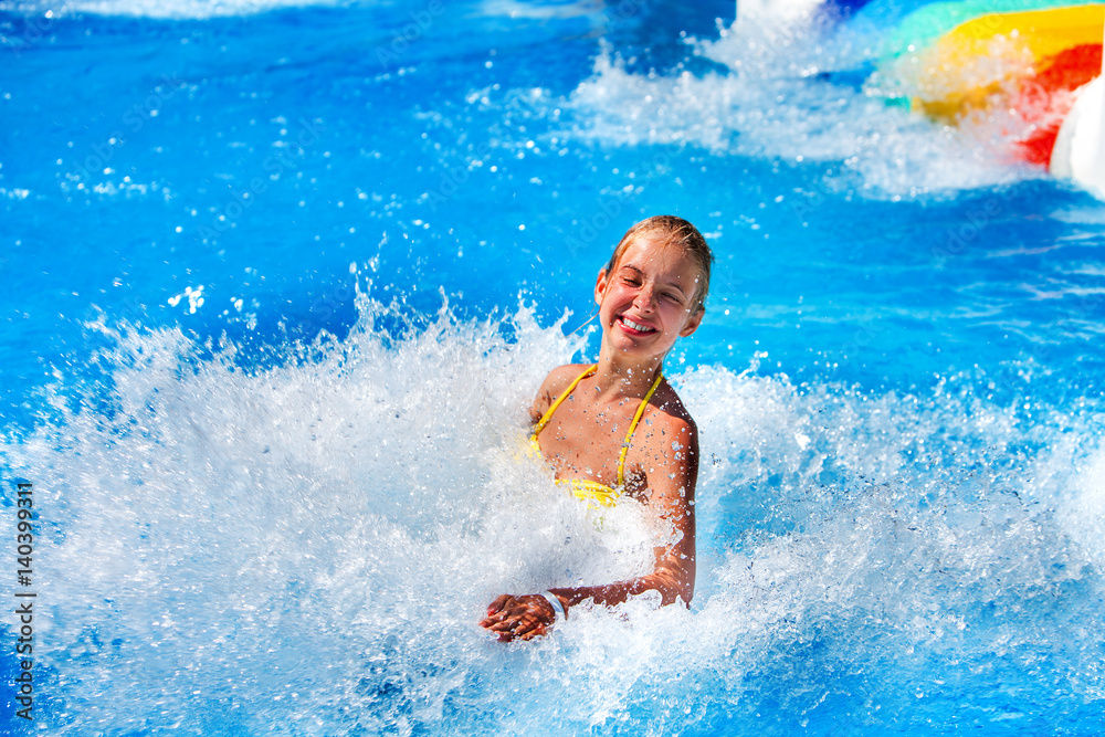 Swimming pool slides for children on water slide at aquapark . Summer kid holiday outdoor. Little girl in aqua park.