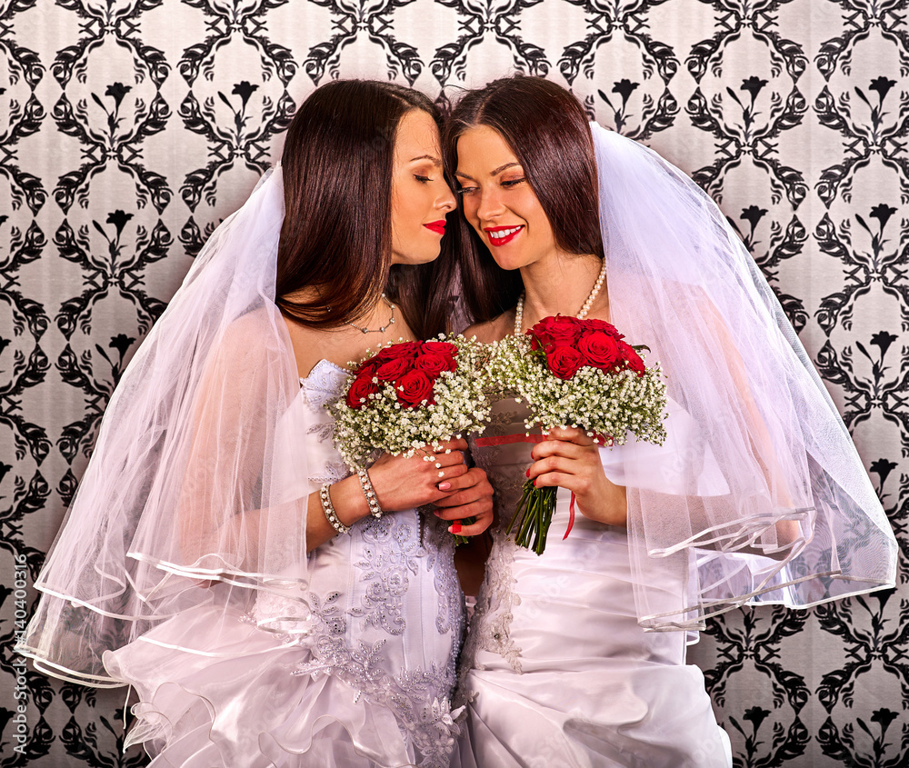 Lesbian couples in wedding bridal dress kissing . same-sex marriage and love couple with flower bunch