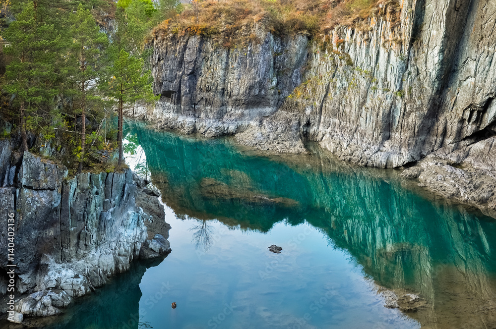 Turquoise water of Katun river surrounded by steep cliffs. Near the island Patmos in Altai mountains, Siberia, Russia