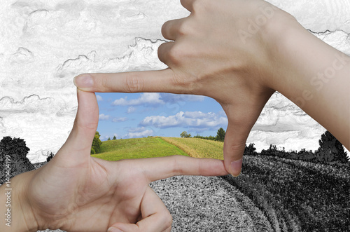 hands creating a square turning a drawing of a clean landscape into reality