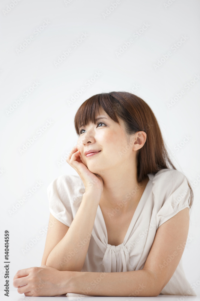 Young woman on white background, resting chin on hand Young woman on white background, resting chin on hand