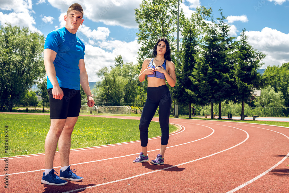 Fototapeta premium Two young athletes on track field.