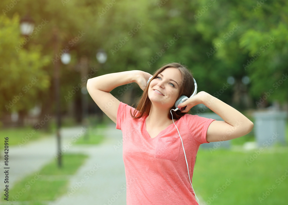 Pregnant woman listening to music with headphones   outdoors