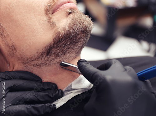 Hairdresser shaving client ...