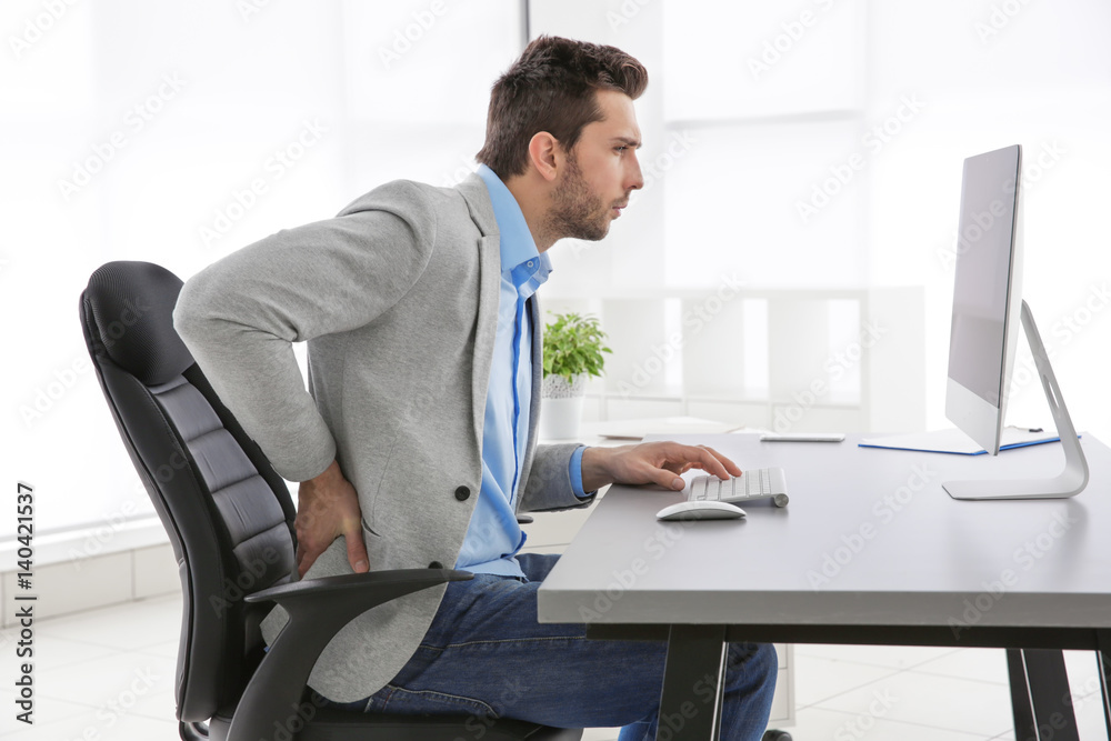Fototapeta premium Incorrect posture concept. Man sitting at office table