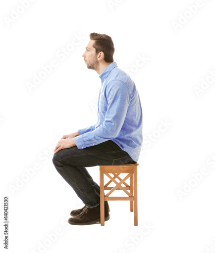 Incorrect posture concept. Man sitting on chair isolated on white © Africa Studio