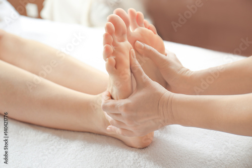 Young woman receiving foot massage in spa salon