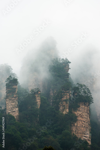 mountains are surrounded by clouds at Zhangjiajie  a national park in China known for its surreal scenery of rock formations.