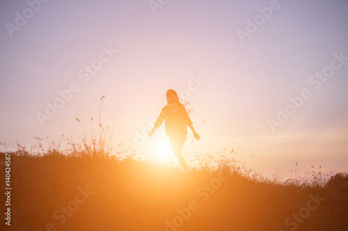 A cheerful woman run at the sun