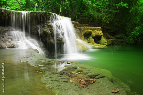 waterfall with clear green emerald water and rock for relax with tree and root in the jungle at Huay Mae Khamin waterfall for nature landscape and background
