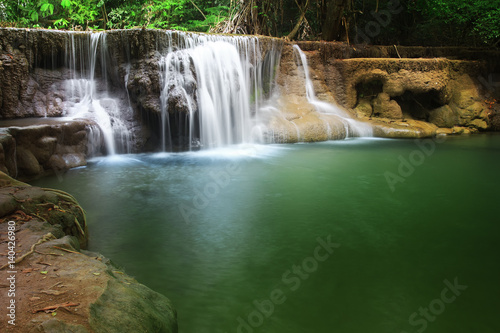 waterfall with clear green water and rock for relax with tree and root in the jungle at Huay Mae Khamin waterfall for nature landscape